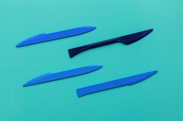 Blue plasticine knives for cutting plasticine on a mint background. Flat lay, copy space, top view. Hobby.