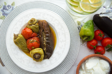 Eggplants are stuffed with meat lamb and rice. Patlican . eggplant filling . Eggplant, peppers, tomatoes . Yogurt in a brown bowl . Chopped lemon in a glass jar . Stuffed eggplant in the plate .