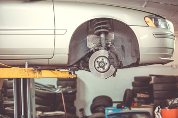 Car service center concept, vehicle raised on lift at maintenance station, auomobile repair and check up, repairing car