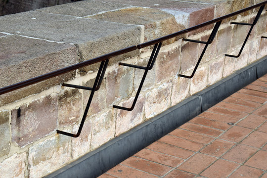 Black Metal Handrail on Stone Wall with Metal Drainage Channel & Brick Paving 