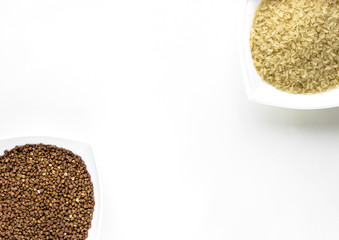 close up of white cups of buckwheat and rice layout on white isolated background. asian food and kitchen concept 