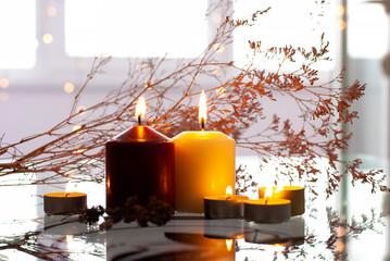 Beautyful burning light yellow creme vanilla red candles with bright flame and towels of natural color in the background