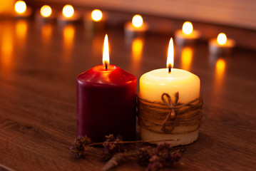 Obraz na płótnie Canvas Aromatherapy flame closeup picture. Beautyful burning light yellow creme vanilla and red candles with wooden background
