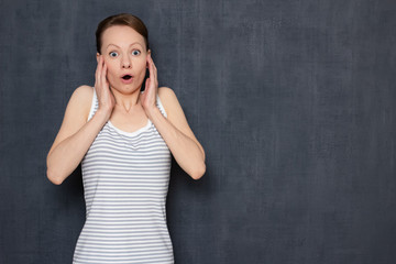 Portrait of shocked surprised girl with widened eyes and open mouth