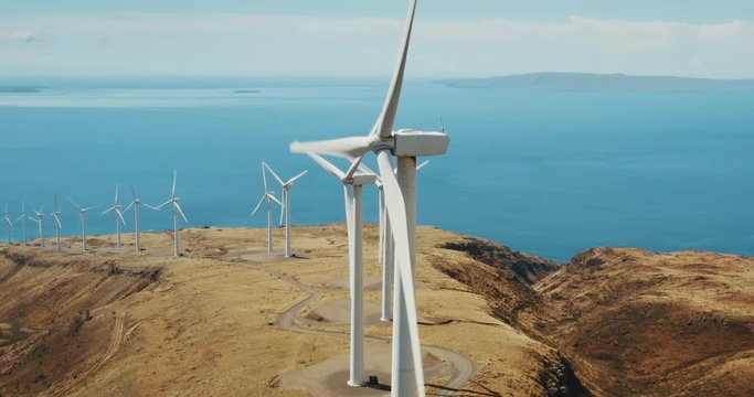 Cinematic aerial view of large wind turbines producing clean sustainable energy, clean energy future