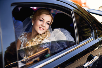Obraz na płótnie Canvas bride looking throw the window of black car