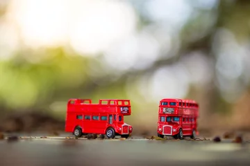 Tafelkleed toys that represent two of the main symbols of the city of London, double-decker bus on blurred background. selective focus and grain nose. © stockchalathan