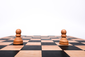 Two white pawns separated at different ends of a chess board. Conceptual image representing...