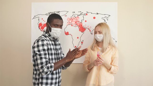 International family in medical masks promotes the use of hand antiseptic. Preventive action during a pandemic and coronavirus infection.