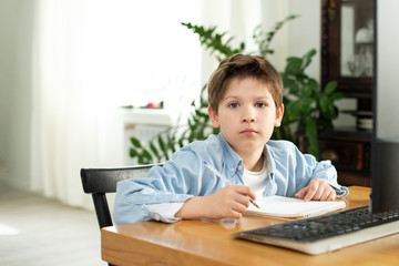 Distance learning during isolation during quarantine in coronavirus. Boy and laptop at home. Lifestyle