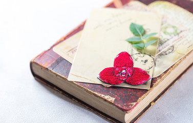 Brooch orchid, red lycast, on a vintage book. Handmade.