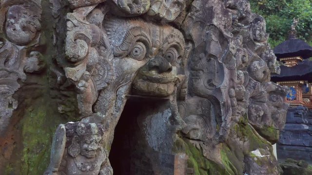 Nice pan across the cave, stupas and ancient pools of the Goa Gajah Elephant Cave Hindu Temple in Ubud, Bali in the morning of this tourism exotic vacation island