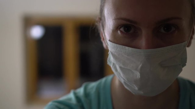 Night shift doctor. Woman doctor wearing mask and tired at evening. Pandemic time.