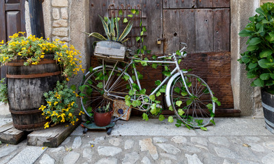 Fototapeta na wymiar Old and decorative bicycle leaning against old wooden door at traditional village in Spain
