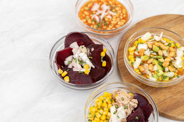 Mixed salads with avocado corn beans beet and onions in bowls