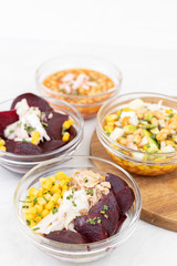 Mixed salads with avocado corn beans beet and onions in bowls
