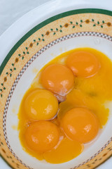 Raw eggs yolks in the bowl on the table