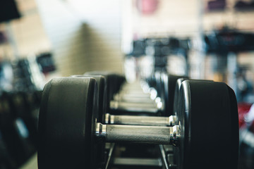Fototapeta na wymiar Dumbbells in the interior of the gym without people