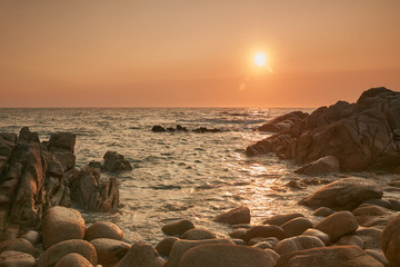 Sunset over rocks rounded by wave erosion