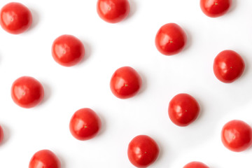 Modern minimalistic natural pattern, pink tomatoes on a white background. Summer and autumn concept. Flat lay.