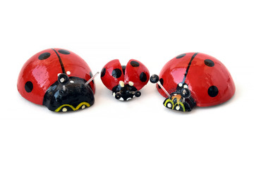 Wooden ladybugs on a white background. Three toy insects