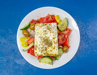 Greek salad plate with original feta cheese, olives, green pepper slices, tomatoes, onions and cucumber slices