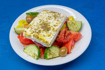 Greek salad plate with original feta cheese, olives, green pepper slices, tomatoes, onions and cucumber slices