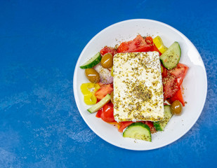 Greek salad plate with original feta cheese, olives, green pepper slices, tomatoes, onions and cucumber slices