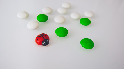 tablets or candies, white and colored on a white table 