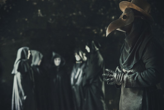 Misterical ritual scene of dark mass. Plague doctor and a crowd in masks and hoods. Toned and noise art image