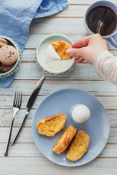 Breakfast with fried croutons, yogurt and black tea on light wooden background. Summer country food.