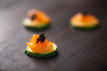 small catering snacks, cucumber with smoked salmon and black caviar