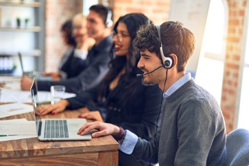 Group of call center workers smiling happy and confident. Working together with smile on face using headset at the office.