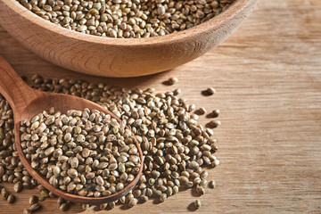 hemp seeds and a wooden spoon on a dark table. Wooden bowl on Cutting board. Healthy food concept.