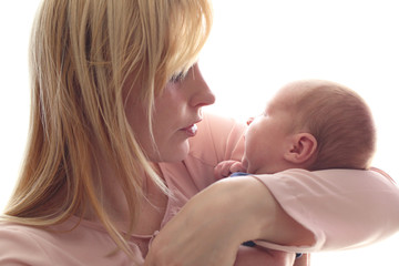 Loving mom holds her newborn baby in her arms, cute tiny baby. Portrait a Mom and her baby. The concept of a happy family. Beautiful conceptual image of motherhood. Mothers Day.