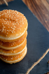 buns with sesame for burgers. black stone tray.