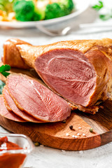 Sliced turkey drumstick on a cutting board close-up. Roasted turkey drumstick selective focus.