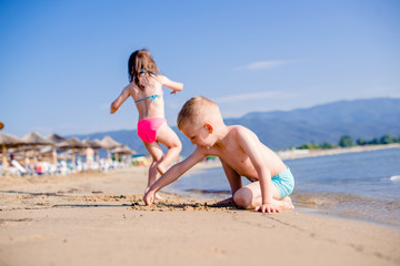 Little boy is drawing in sand