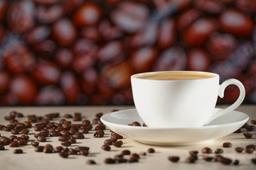 A white cappuccino Cup on the marble table. Coffee beans on the table