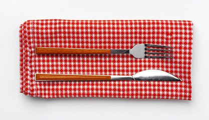 Set of fork and knife on towel. Isolated on white background. Close up.