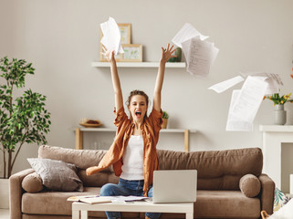 Happy young woman freelancer throwing papers.