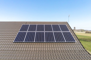 Panele fotowoltaiczne na dachu w słoneczny dzień. Fotowoltaika, dach, energia słoneczna - obrazy, fototapety, plakaty
