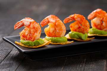 shrimps served on nacho chips with guacamole