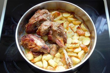 Roast lamb with potatoes in a pan fresh out of the oven homemade, top view