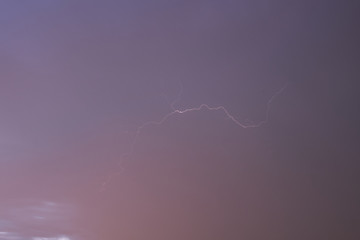Lightning on a dark pink blue sky
