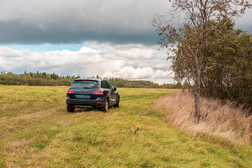 Off-road car on the background of the autumn landscape