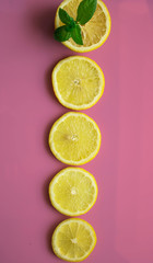 sliced lemon with mint leaves isolated on pink