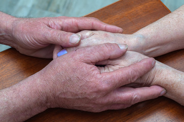 senior family couple holding old hands, psychological support concept