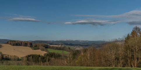 Krkonose mountains in spring sunny day with color meadows and fields