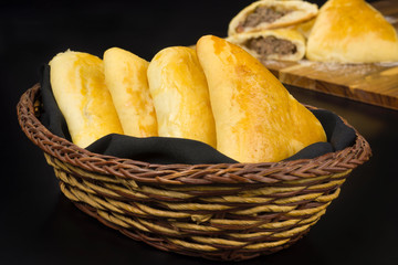Syrian-Lebanese pie called sfiha in a basket in black background